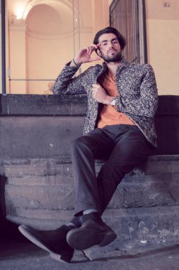 Parma 'nın ortasında, Pilotta' nın merdivenlerinde ceketli, zarif, siyah saçlı İtalyan çocuk. Yüksek kalite fotoğraf