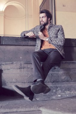 Parma 'nın ortasında, Pilotta' nın merdivenlerinde ceketli, zarif, siyah saçlı İtalyan çocuk. Yüksek kalite fotoğraf