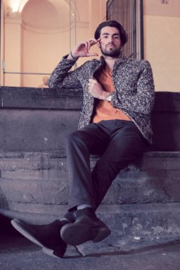 Parma 'nın ortasında, Pilotta' nın merdivenlerinde ceketli, zarif, siyah saçlı İtalyan çocuk. Yüksek kalite fotoğraf