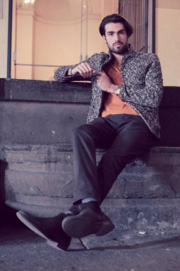 Parma 'nın ortasında, Pilotta' nın merdivenlerinde ceketli, zarif, siyah saçlı İtalyan çocuk. Yüksek kalite fotoğraf