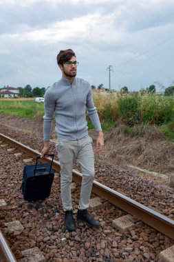 İntihar ile hayal kırıklığına uğrayan bir adam tren raylarında amaçsızca yürür. Yüksek kalite fotoğraf