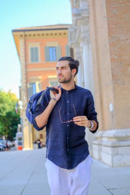 Güzel siyah saçlı İtalyan çocuk alışveriş çantasıyla şehir merkezine yürür. Yüksek kalite fotoğraf