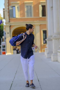 Güzel siyah saçlı İtalyan çocuk alışveriş çantasıyla şehir merkezine yürür. Yüksek kalite fotoğraf
