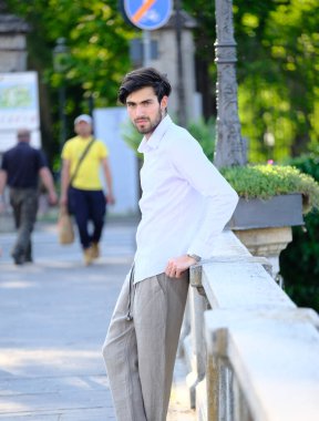 Beyaz gömlekli ve güneş gözlüklü yakışıklı, siyah saçlı bir İtalyan. Yüksek kalite fotoğraf