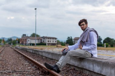 İtalyan koyu renk saçlı çocuk tren peronunda gözlükleriyle bekliyor. Yüksek kalite fotoğraf