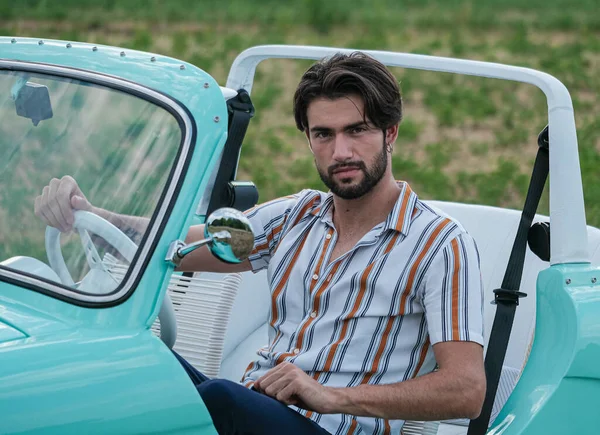 İtalyan esmer çocuk, klasik bir arabanın yanında poz veriyor. Autobianchi Bianchina Spiaggina. Yüksek kalite fotoğraf