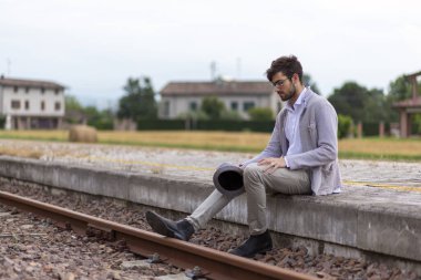 İtalyan koyu renk saçlı çocuk tren peronunda gözlükleriyle bekliyor. Yüksek kalite fotoğraf