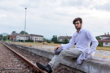 İtalyan koyu renk saçlı çocuk tren peronunda gözlükleriyle bekliyor. Yüksek kalite fotoğraf