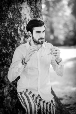 Beyaz gömlekli ve güneş gözlüklü yakışıklı, siyah saçlı bir İtalyan. Yüksek kalite fotoğraf