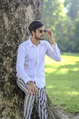 Beyaz gömlekli ve güneş gözlüklü yakışıklı, siyah saçlı bir İtalyan. Yüksek kalite fotoğraf