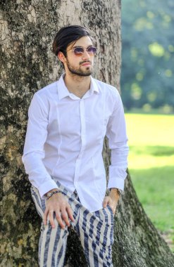 Beyaz gömlekli ve güneş gözlüklü yakışıklı, siyah saçlı bir İtalyan. Yüksek kalite fotoğraf