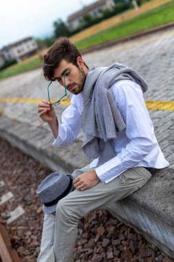 İtalyan koyu renk saçlı çocuk tren peronunda gözlükleriyle bekliyor. Yüksek kalite fotoğraf