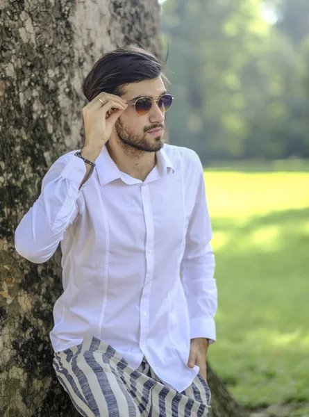 Beyaz gömlekli ve güneş gözlüklü yakışıklı, siyah saçlı bir İtalyan. Yüksek kalite fotoğraf