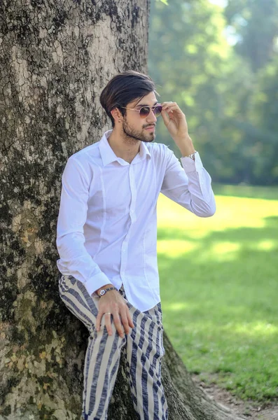 Beyaz gömlekli ve güneş gözlüklü yakışıklı, siyah saçlı bir İtalyan. Yüksek kalite fotoğraf