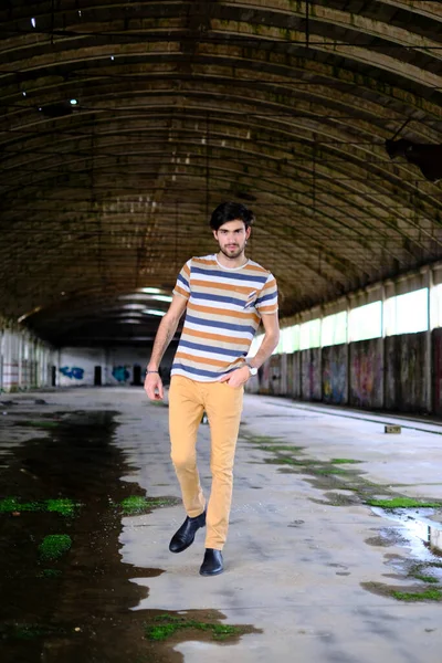 İtalyan esmer çocuk terk edilmiş fabrikada yürüyor. Yüksek kalite fotoğraf