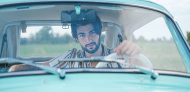 İtalyan esmer çocuk, klasik bir arabanın yanında poz veriyor. Autobianchi Bianchina Spiaggina. Yüksek kalite fotoğraf