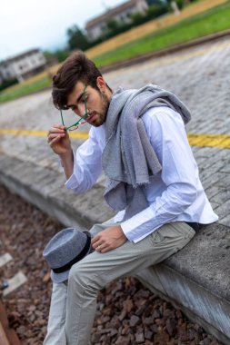 İtalyan koyu renk saçlı çocuk tren peronunda gözlükleriyle bekliyor. Yüksek kalite fotoğraf