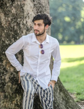 Beyaz gömlekli ve güneş gözlüklü yakışıklı, siyah saçlı bir İtalyan. Yüksek kalite fotoğraf