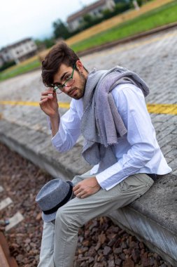 İtalyan koyu renk saçlı çocuk tren peronunda gözlükleriyle bekliyor. Yüksek kalite fotoğraf