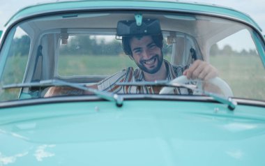 İtalyan esmer çocuk, klasik bir arabanın yanında poz veriyor. Autobianchi Bianchina Spiaggina. Yüksek kalite fotoğraf