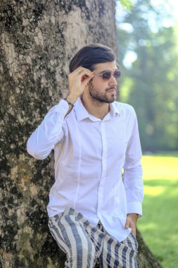 Beyaz gömlekli ve güneş gözlüklü yakışıklı, siyah saçlı bir İtalyan. Yüksek kalite fotoğraf