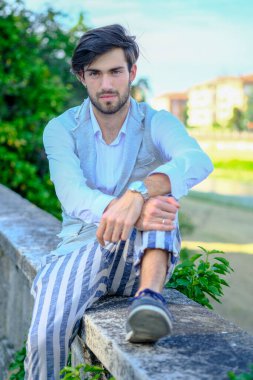 Beyaz gömlekli ve güneş gözlüklü yakışıklı, siyah saçlı bir İtalyan. Yüksek kalite fotoğraf