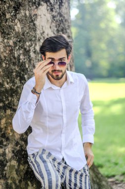 Beyaz gömlekli ve güneş gözlüklü yakışıklı, siyah saçlı bir İtalyan. Yüksek kalite fotoğraf