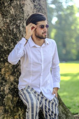 Beyaz gömlekli ve güneş gözlüklü yakışıklı, siyah saçlı bir İtalyan. Yüksek kalite fotoğraf