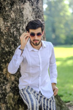 Beyaz gömlekli ve güneş gözlüklü yakışıklı, siyah saçlı bir İtalyan. Yüksek kalite fotoğraf