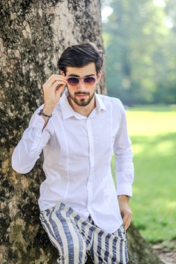 Beyaz gömlekli ve güneş gözlüklü yakışıklı, siyah saçlı bir İtalyan. Yüksek kalite fotoğraf