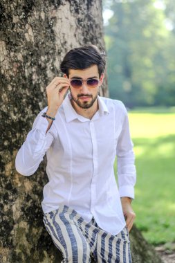 Beyaz gömlekli ve güneş gözlüklü yakışıklı, siyah saçlı bir İtalyan. Yüksek kalite fotoğraf