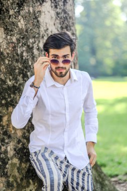 Beyaz gömlekli ve güneş gözlüklü yakışıklı, siyah saçlı bir İtalyan. Yüksek kalite fotoğraf