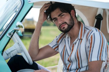 İtalyan esmer çocuk, klasik bir arabanın yanında poz veriyor. Autobianchi Bianchina Spiaggina. Yüksek kalite fotoğraf