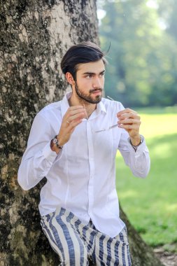 Beyaz gömlekli ve güneş gözlüklü yakışıklı, siyah saçlı bir İtalyan. Yüksek kalite fotoğraf