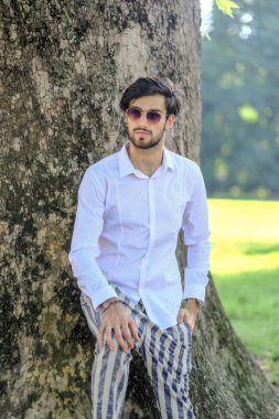 Beyaz gömlekli ve güneş gözlüklü yakışıklı, siyah saçlı bir İtalyan. Yüksek kalite fotoğraf