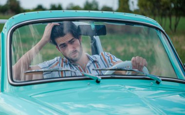 İtalyan esmer çocuk, klasik bir arabanın yanında poz veriyor. Autobianchi Bianchina Spiaggina. Yüksek kalite fotoğraf