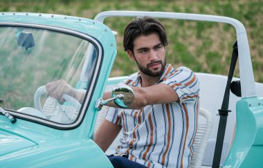 İtalyan esmer çocuk, klasik bir arabanın yanında poz veriyor. Autobianchi Bianchina Spiaggina. Yüksek kalite fotoğraf