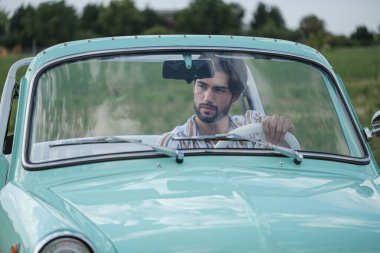 İtalyan esmer çocuk, klasik bir arabanın yanında poz veriyor. Autobianchi Bianchina Spiaggina. Yüksek kalite fotoğraf
