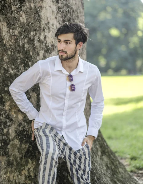 Beyaz gömlekli ve güneş gözlüklü yakışıklı, siyah saçlı bir İtalyan. Yüksek kalite fotoğraf