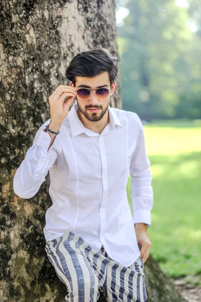 Beyaz gömlekli ve güneş gözlüklü yakışıklı, siyah saçlı bir İtalyan. Yüksek kalite fotoğraf