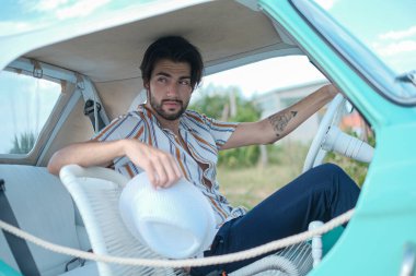 İtalyan esmer çocuk, klasik bir arabanın yanında poz veriyor. Autobianchi Bianchina Spiaggina. Yüksek kalite fotoğraf