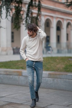 Şehir merkezinde sakallı, beyaz kazaklı yakışıklı, siyah saçlı bir İtalyan. Yüksek kalite fotoğraf