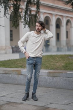 Şehir merkezinde sakallı, beyaz kazaklı yakışıklı, siyah saçlı bir İtalyan. Yüksek kalite fotoğraf