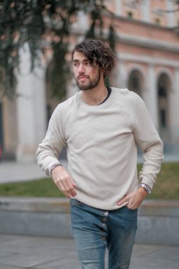 Şehir merkezinde sakallı, beyaz kazaklı yakışıklı, siyah saçlı bir İtalyan. Yüksek kalite fotoğraf