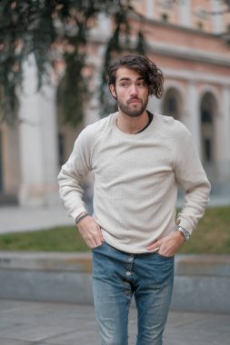 Şehir merkezinde sakallı, beyaz kazaklı yakışıklı, siyah saçlı bir İtalyan. Yüksek kalite fotoğraf