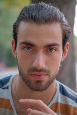 Çizgili tişörtlü, yakışıklı, siyah saçlı çocuğun portresi. Yüksek kalite fotoğraf