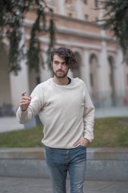 Şehir merkezinde sakallı, beyaz kazaklı yakışıklı, siyah saçlı bir İtalyan. Yüksek kalite fotoğraf