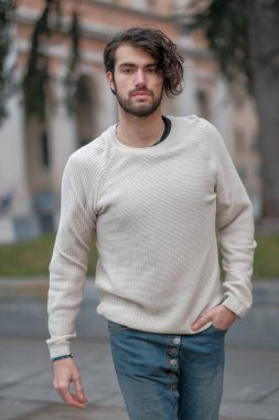 Şehir merkezinde sakallı, beyaz kazaklı yakışıklı, siyah saçlı bir İtalyan. Yüksek kalite fotoğraf