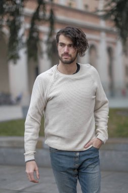 Şehir merkezinde sakallı, beyaz kazaklı yakışıklı, siyah saçlı bir İtalyan. Yüksek kalite fotoğraf