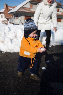 Küçük çocuk karda gülümser ve oynar. Yüksek kalite fotoğraf